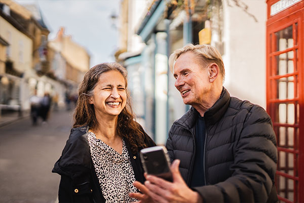 Man and woman laughing looking at phone