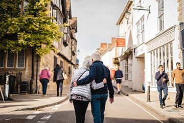 Couple walking arm in arm down the street