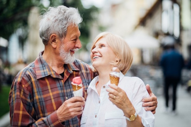 Senior couple hugging holding ice cream cones