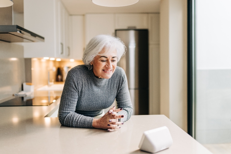 Senior woman talking to a virtual assistant