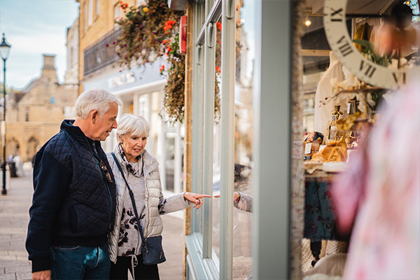 Couple walking hand in hand looking in shop windows