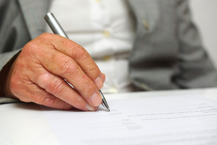 Senior writing with a silver pen