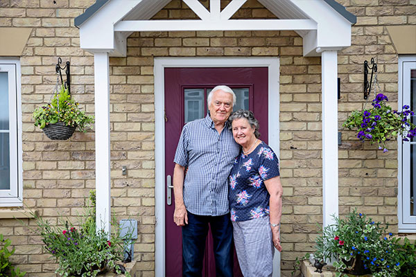 Couple outside their home